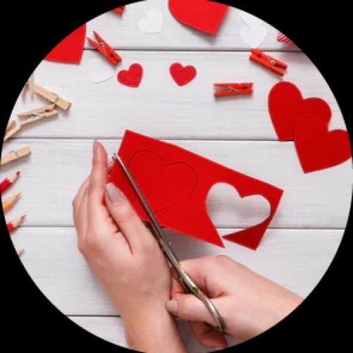 Crafting session: hands cutting a paper heart