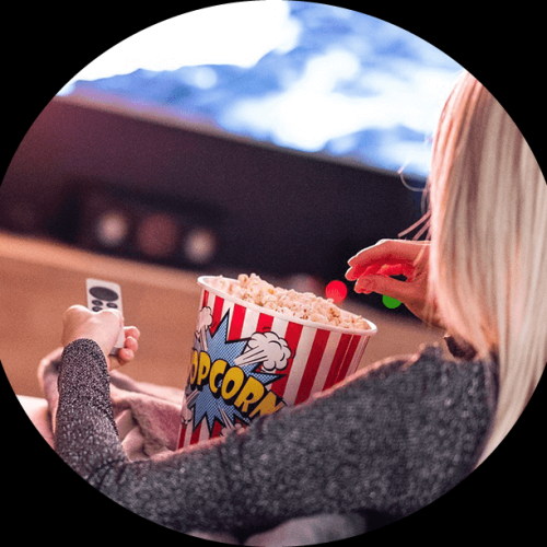 Movie marathon: a woman with popcorn and a remote control