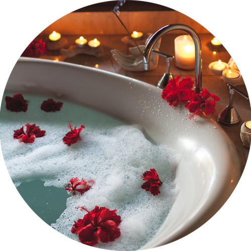 Self-care spa night: a bubble bath with candles and rose petals